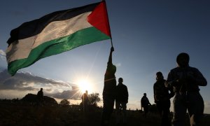 Manifestantes despliegan una bandera de Palestina durante una protesta junto a la frontera en Gaza. - REUTERS