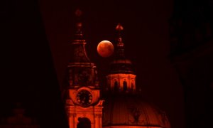 La luna de sangre vista entre la iglesia de San Nicolás, en Praga, República Checa. Michal CIZEK / AFP