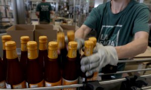 Trabajadores en una línea de embotellado de una fábrica de cerveza, en Madrid. REUTERS/Sergio Perez