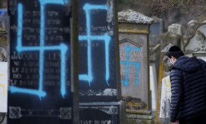 Un hombre camina entre las tumbas que fueron profanadas con esvásticas en el cementerio judío de Quatzenheim. / Reuters