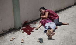 Kevin Ignacio Vázquez de 17 años yace muerto en brazos de su madre tras ser asesinado a tiros frente a la escuela del Barrio Cabañas de San Pedro Sula. Esta ciudad es el punto más violento de Honduras y en 2010 se convirtió en la ciudad más violenta del