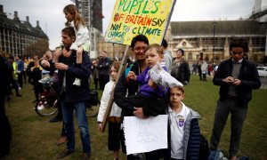 Una madre se manifiesta contra el cambio climático junto a sus hijos en el Reino Unido./ REUTERS