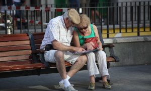 Una pareja de pensionistas, en un banco en la calle.