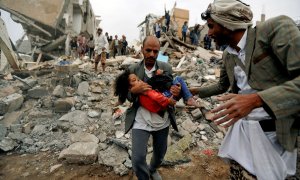 Un hombre lleva en brazos a una niña herida en un bombardeo de la coalición saudí contra Yemen en agosto de 2017. Khaled Abdullah / REUTERS