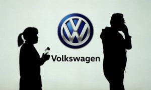 Dos personas pasan delate del logo de Volkswagen en la Feria del Automóvil de Shangai. (REUTERS)