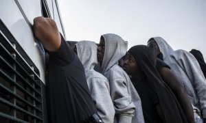 Varios migrantes suben a un autobús de la Guardia Civil para ser trasladados desde el puerto de Algeciras, en agosto de 2018.- JAIRO VARGAS (ARCHIVO)