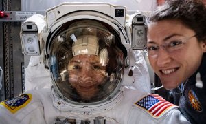 La astronauta Christina Koch (derecha) posa con su compañera de la NASA Jessica Meir (izquierda), que está dentro de un traje espacial verificando su ajuste. / NASA