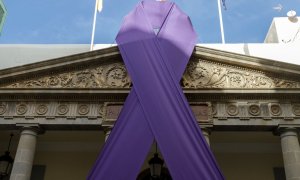 Un gran lazo morado cuelga del Parlamento de Canarias, comunidad en la que se ha producido el último asesinato machista./ Ramón de la Rocha (EFE)