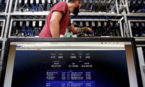 Un empleado trabaja en el ordenador de minería de Bitcoin mientras  una pantalla de PC muestra las fluctuaciones de la criptomoneda, en Florencia, Italia. REUTERS/Alessandro Bianchi