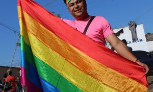 Mavisa, una mujer transexual que viaja en la caravana de migrantes hondureños, posa con la bandera de arcoíris | EFE