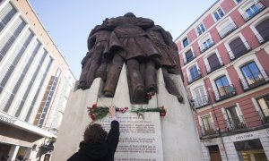 Una mujer coloca un ramo de flores en el monumento al crimen de Atocha / EFE (INMA FLORES)