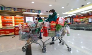 Una mujer con máscara compra en un supermercado en Wuhan. EFE