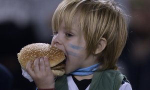 Un niño argentino se come una hamburguesa. Juan MABROMATA. AFP