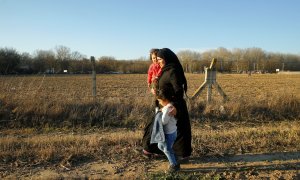 28/02/2020 - Una mujer migrante camina con niños al cruce fronterizo Pazarkule de Turquía. REUTERS / Huseyin Aldemir