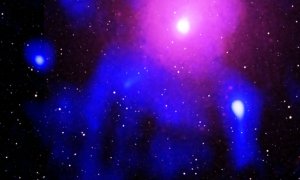 El gas en rosa que rodea la galaxia centralimita con las emisiones de radio (en azul) en el borde de la cavidad causa por la explosión. /XMM/2MASS/GMRT