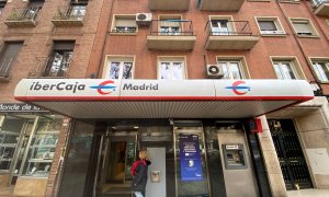 Una mujer entra en un una oficina de IberCaja en Madrid. E.P./Eduardo Parra