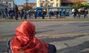 Una mujer al lado de la parada del bus, observando a la policía, Mitilini, Lesbos.