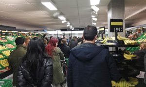 Decenas de personas esperan a pagar su compra en un supermercado en Madrid. EFE/Juan Vargas