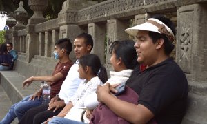 Una familia mexicana sentada junto a un monumento. | Anna Portella