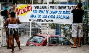 Las entradas principales del Complexo do Alemão (Río de Janeiro), uno de los complejos de favelas más grandes de Brasil, cuentan con pancartas de aviso a los vecinos. COLETIVO PAPO RETO.