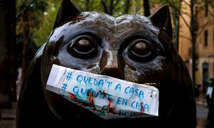 Una mascarilla de fabricación casera con la advertencia ‘’Quedate en casa’’ protege la boca de la escultura "El gato", del escultor colombiano Fernando Botero, en la Rambla del Raval de Barcelona, este lunes en el que los españoles encaran una nueva seman