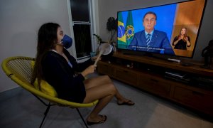 Una mujer con una máscarilla protesta golpeando una olla durante una declaración televisda del presidente de Brasil, Jair Bolsonaro, este martes en Brasilia (Brasil). EFE/Joédson Alves
