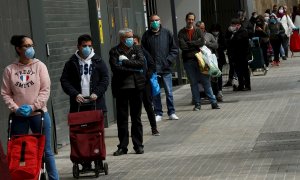Varios clientes guardan cola para entrar en un supermercado de la Gran Via de Barcelona, este miércoles, cuando se cumple el undécimo día del estado de alarma decretado por el Gobierno por la pandemia de coronavirus. EFE/Toni Albir