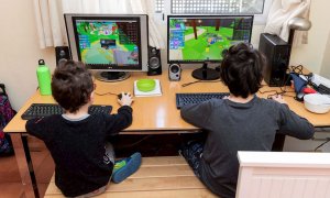 Dos infants juguen amb videojocs a casa durant el confinament pel coronavirus. EFE