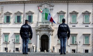 Dos agentes de policía observan la bandera italiana y la de la Unión europea (UE) a media asta, este martes en el Palacio del Quirinal, en Roma (Italia).  | EFE