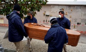 Los empleados de una morgue llevan el ataúd de una persona que murió por la enfermedad del coronavirus (COVID-19), durante el cierre parcial para combatir el brote de la enfermedad, en el cementerio de Carabanchel en Madrid, España, el 27 de marzo de 2020