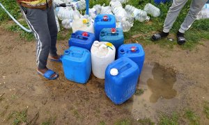 Voluntarios de la Asociación Asnuci junto con otros voluntarios residentes abastecen de agua potable en los asentamientos chabolistas de Lepe. FOTO: Asnuci