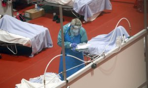 Personal sanitario trabaja en el pabellón 9 del centro de exposiciones Ifema, reconvertido en hospital temporal, durante la puesta en marcha de las primeras UCIs, este miércoles, en Madrid. EFE/J.J. Guillen