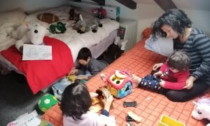 Carmen Nava, de 30 años, juega con sus hijos en la única habitación de su casa alquilada de 35 metros, en las que pasan el confinamiento cinco personas.-CEDIDA