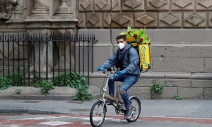 Un ryder de Glovo circula amb la motxilla plena de roses. ACN