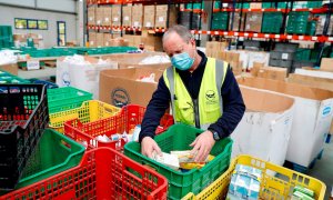 Voluntarios del Banco de Alimentos de Asturias trabajan en el almacén que tienen en el polígono de Argame en Oviedo. EFE/J.L. Cereijido