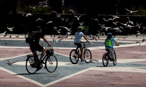 Dos niños y un adulto pasean en bicicleta por la Plaza de Catalunya de Barcelona este martes, cuando se cumplen 45 días de confinamiento por el estado de alarma decretado por el Gobierno por la crisis del coronavirus. EFE/Enric Fontcuberta