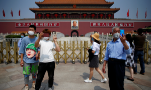 Turistas con mascarilla se toman fotos la puerta de Tiananmen durante las vacaciones de cinco días del Día del Trabajo después del brote de la enfermedad por coronavirus en Beijing. REUTERS / Tingshu Wang