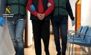 Los agentes conducen al exdiputado de la Duma Estatal rusa buscado por malversación tras su detención. / Guardia Civil