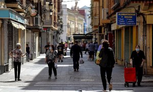 Ciudadanos con mascarillas paseando por una calle de València. /EFE