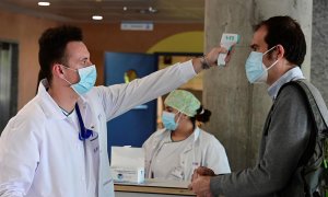Un sanitario toma la temperatura a un hombre que accede al Hospital de Alcorcón en Madrid, este lunes. EFE/Víctor Lerena