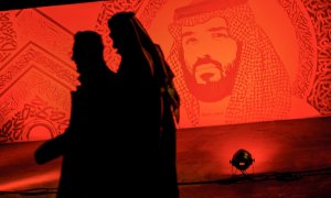 Dos jóvenes pasan junto a un retrato del príncipe heredero de Arabia Saudí Mohammed bin Salman,en una de las principales avenidas de Riad. AFP/FAYEZ NURELDINE