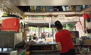 La cambrera del bar-xiringuito Tsunami dels Jardins del Baix Guinardó treballa durant el primer dia amb les terrasses obertes. Maria Rubio