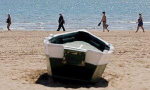 Cuatro personas disfrutan del buen tiempo y del calor en la playa de la Malvarrosa, el pasado viernes. EFE/Kai Försterling