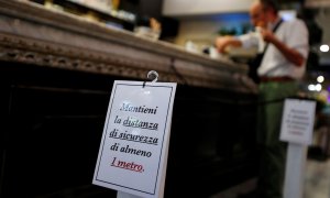 Un cartel en la barra de un bar en Roma pide que se guarde una distancia mínima de seguridad por la pandemia del coronavirus. REUTERS/Guglielmo Mangiapane