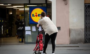 Una mujer espera con su carro de la compra a poder entrar a un supermercado Lidl , en Barcelona. E.P./David Zorrakino