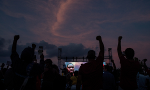 Ciudadanos y ex alumnos de la escuela secundaria de Yates levantan sus puños durante una vigilia en honor a George Floyd, en el campo donde jugó fútbol en Houston, Texas. REUTERS / Adrees Latif