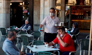 Un camarero sirve a los clientes en su bar de la Plaza Mayor de Salamanca. EFE/JM García