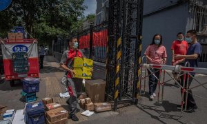 Un repartidor entrega paquetes para los residentes en un complejo residencial cerrado cerca del mercado de Yuquandong, en el distrito de Haidian, Pekín, China. EFE/EPA/ROMAN PILIPEY