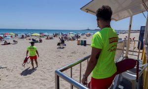 22/06/2020 .- Dos socorristas vigilan a los bañistas que disfrutan del primer día de verano y del primer día de "nueva normalidad" tras el fin del estado de alarma, este domingo en la playa del Mar Menor. EFE/Marcial Guillén