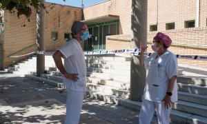 Dos sanitarios conversan en las inmediaciones del polideportivo Cortes de Aragón de Fraga, Huesca este martes | EFE